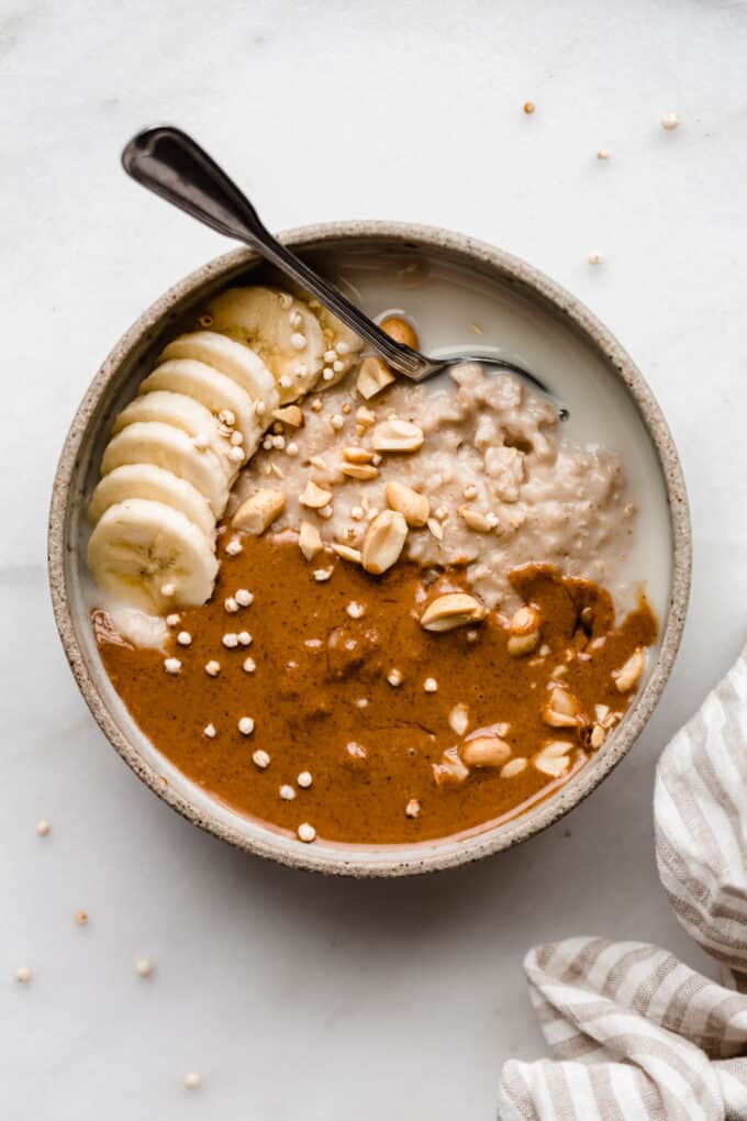 peanut butter oatmeal in a bowl with a striped beige napkin on the side