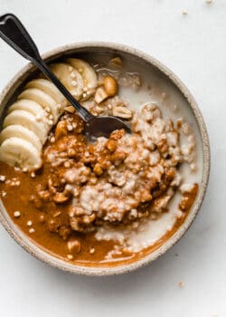 a bowl of peanut butter oatmeal with bananas on top