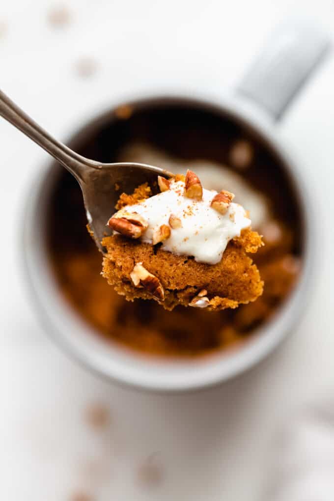 a spoonful of pumpkin cake topped with whipped cream