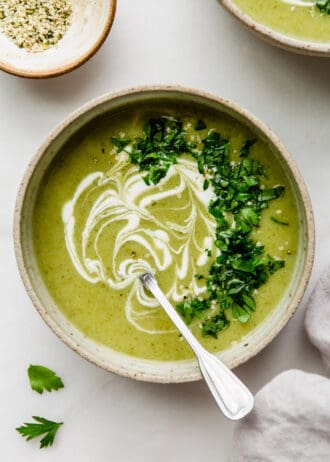 broccoli potato soup in a bowl with sour cream and parsley