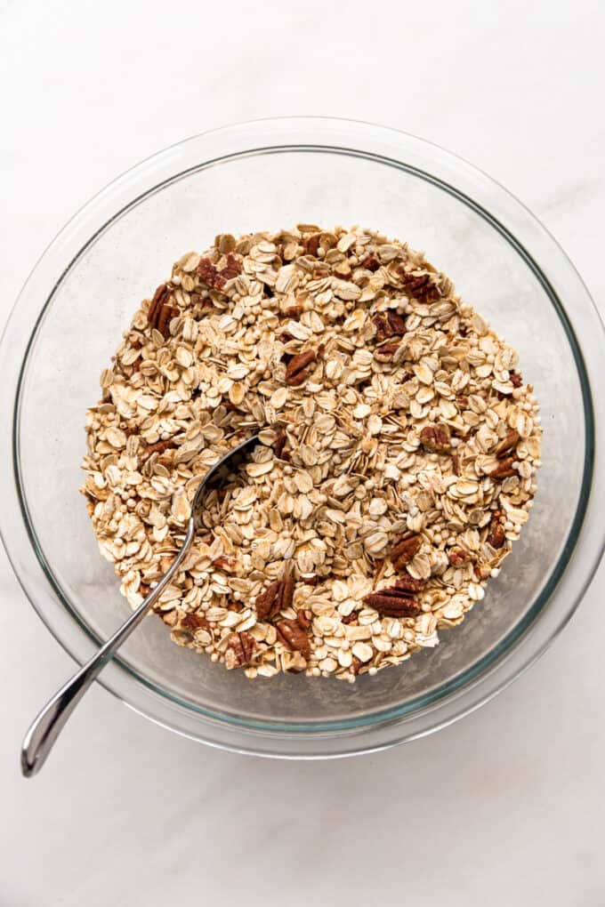 oats, puffed quinoa and pecans mixed together in a mixing bowl