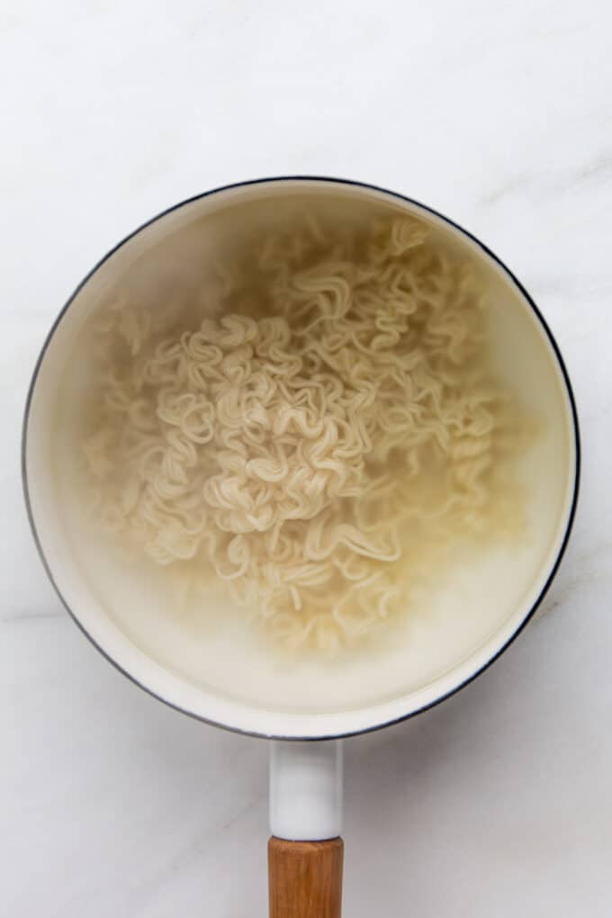 ramen noodles boiling in a pot of water