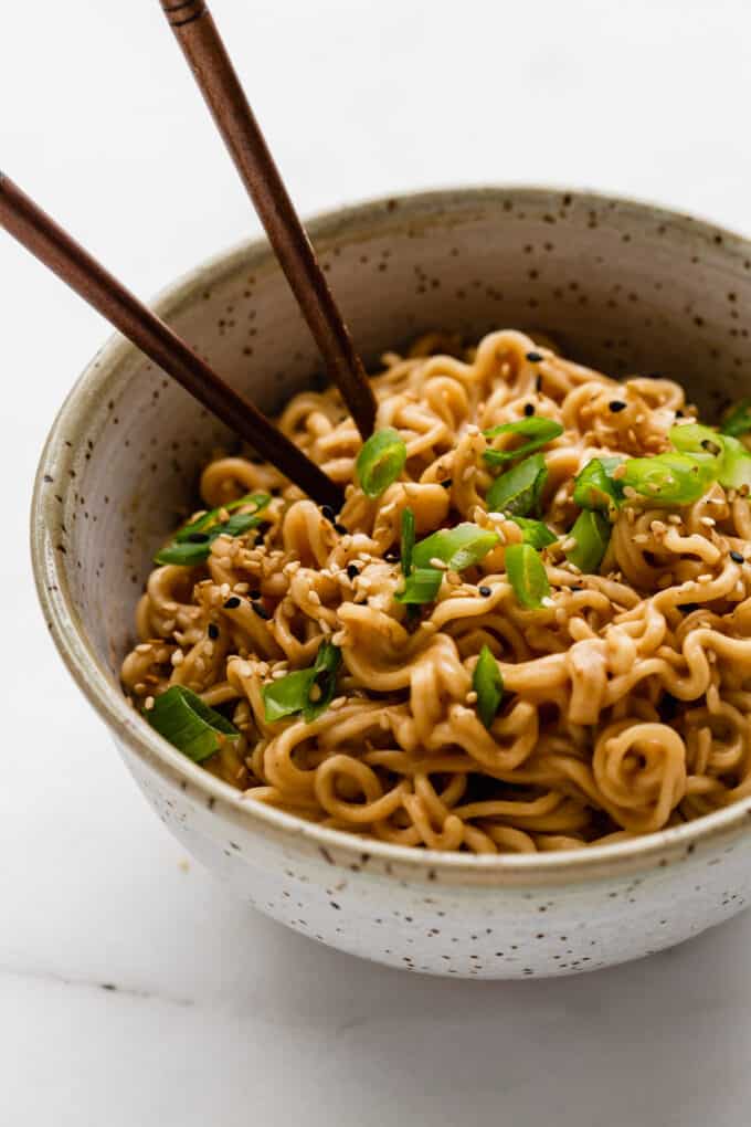 peanut ramen noodles in a bowl with green onions