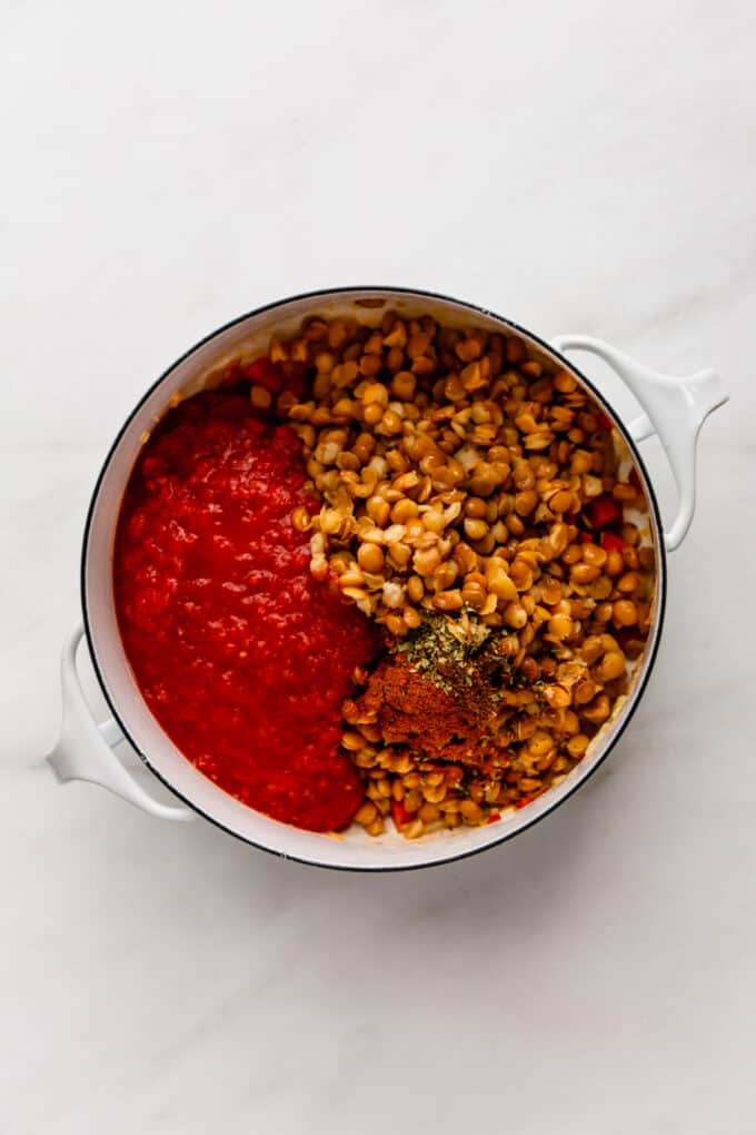 lentils, spices and crushed tomatoes in a white pot