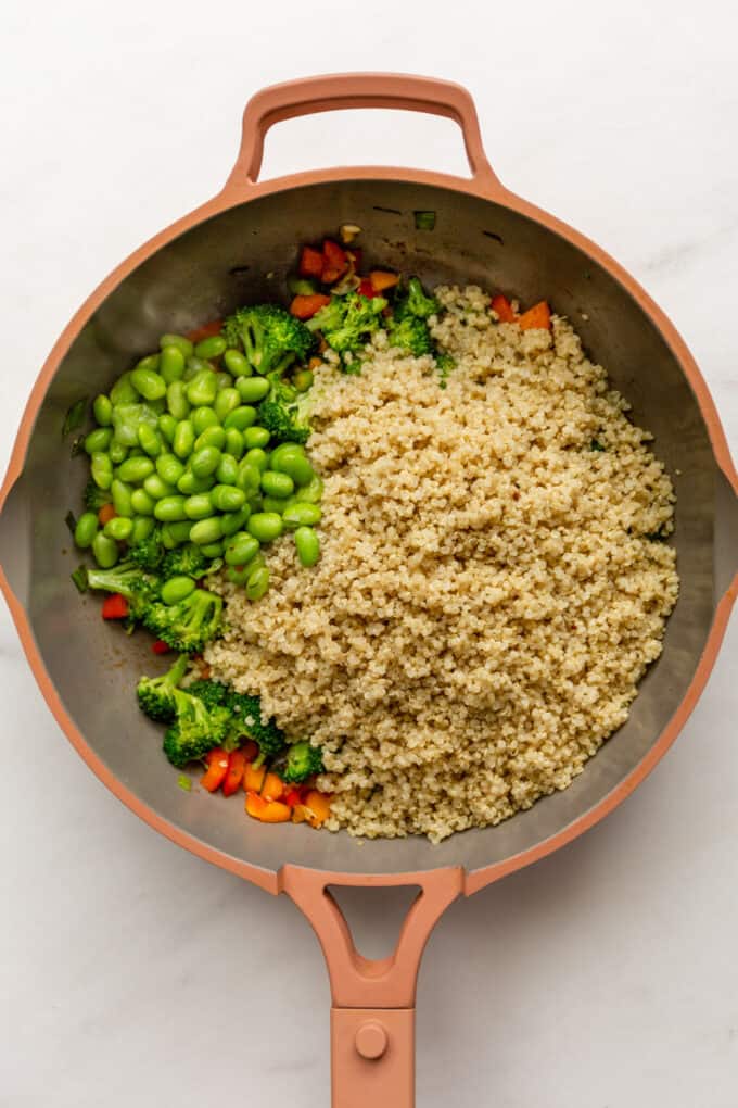 quinoa, edamame beans and vegetables in a pink pan
