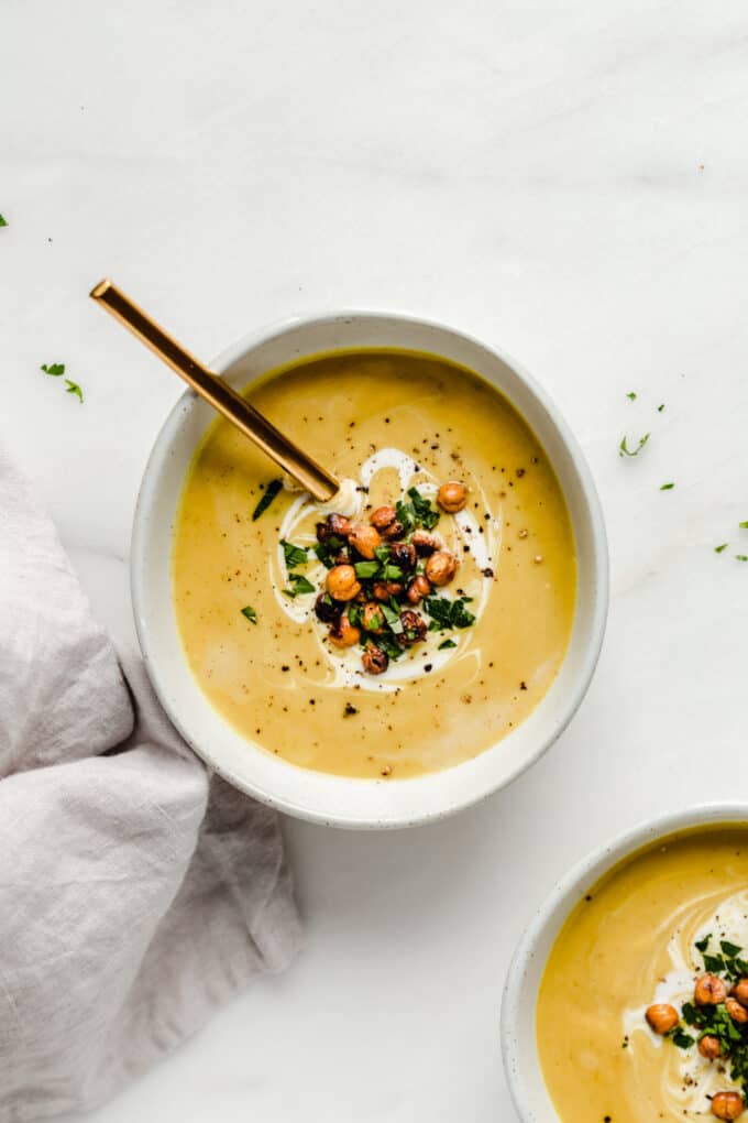 a bowl of curried cauliflower soup topped with crispy chickpeas and cilantro