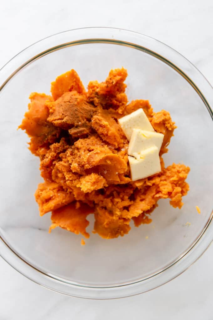 sweet potato, butter and cinnamon in a clear mixing bowl