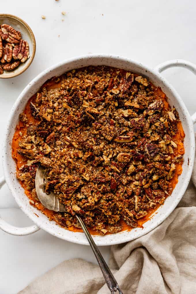 ssweet potato casserole topped with pecan crumble in a round serving dish