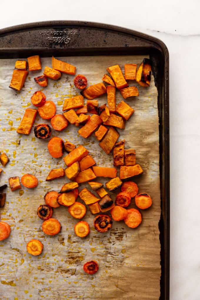 roasted sweet potatoes and carrots on a baking pan