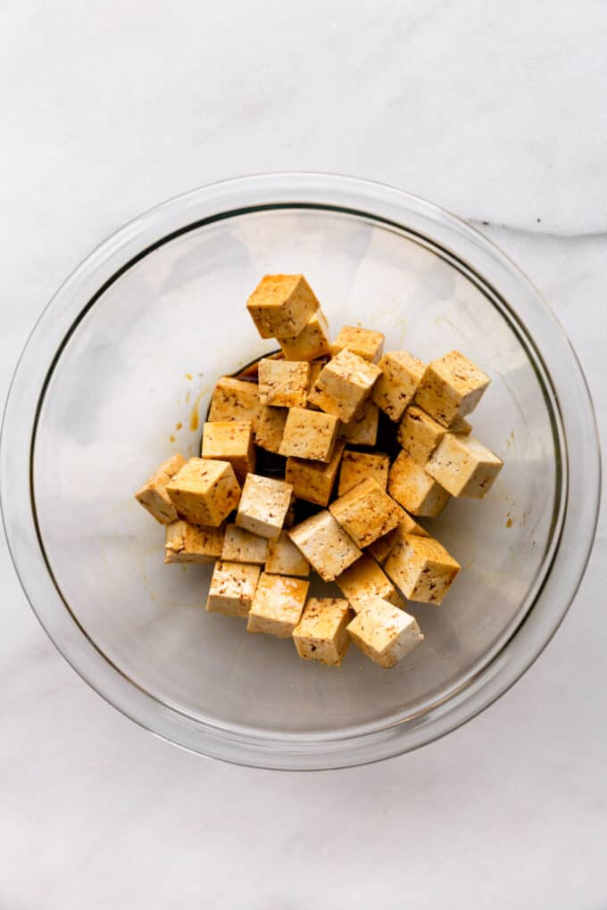 cubes of tofu and tamari in a mixing bowl