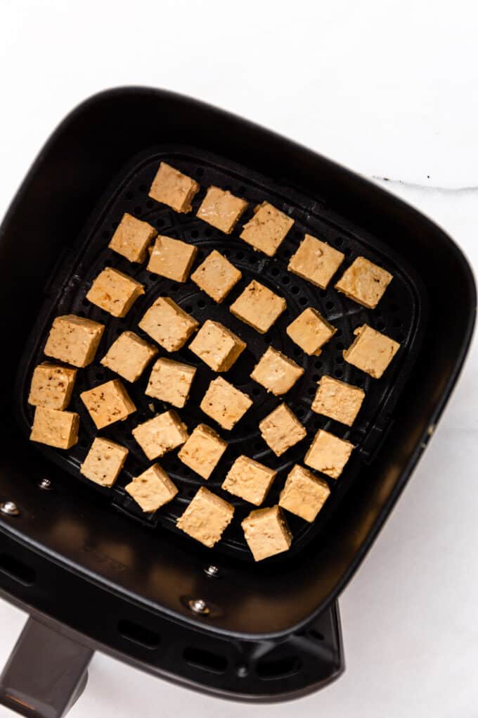 uncooked tofu in an air fryer tray