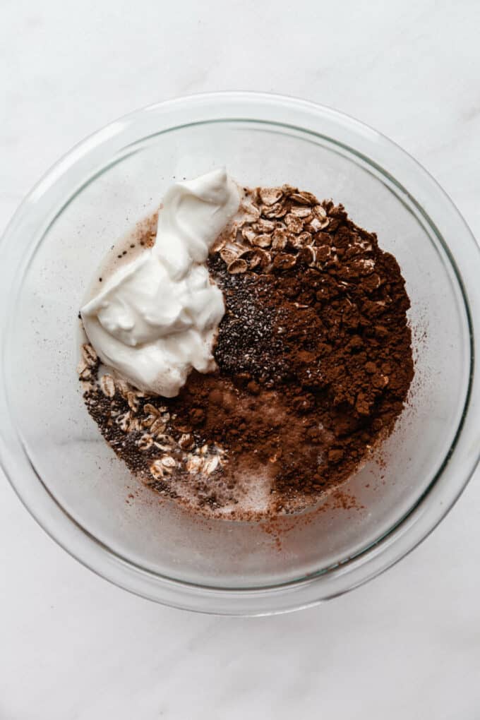 oats, cocoa powder, chia seeds and yogurt in a bowl