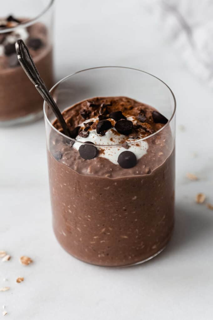 a cup of chocolate overnight oats with a spoon in it