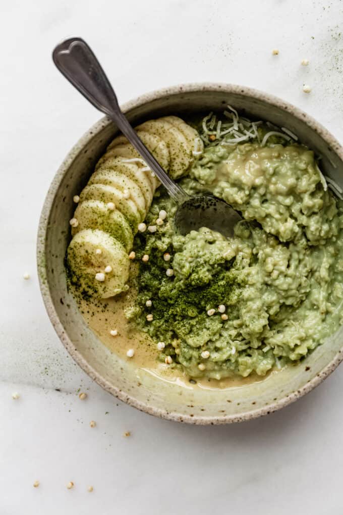 matcha oatmeal in a bowl topped with bananas and matcha powder