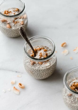 three jars of peanut butter chia pudding topped with peanut granola