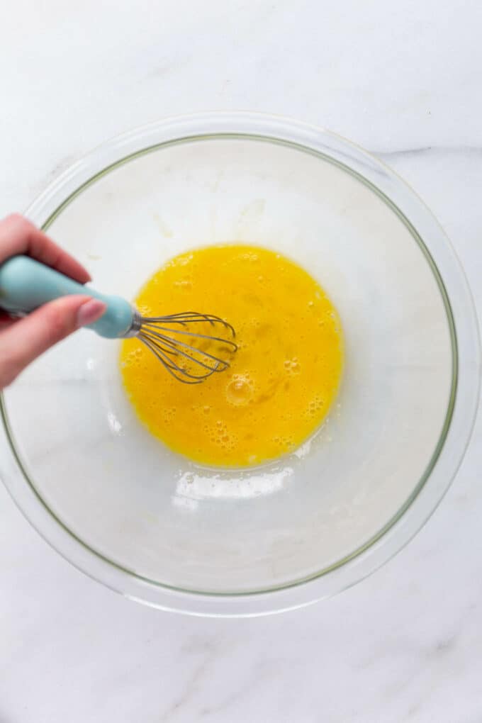 eggs being whisked in a mixing bowl