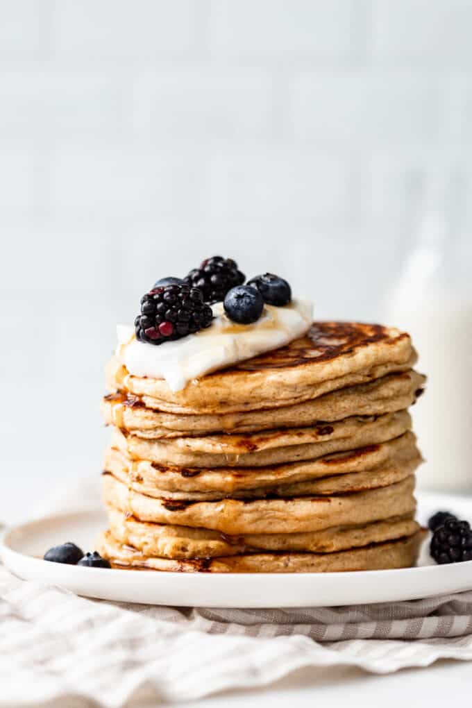 cottage cheese pancakes stacked on a plate topped with berries