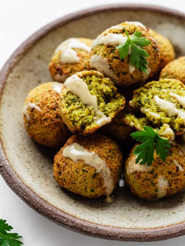 falafel on a ceramic plate drizzled with tahini