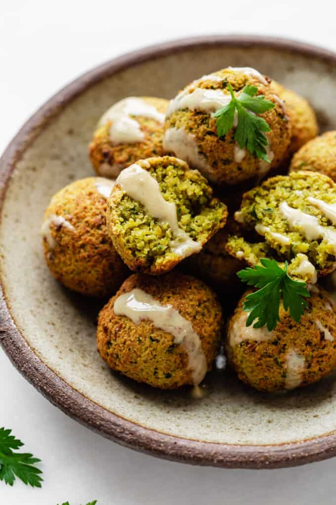 falafel on a ceramic plate drizzled with tahini