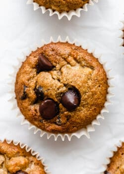 a banana oat flour muffin topped with chocolate chips