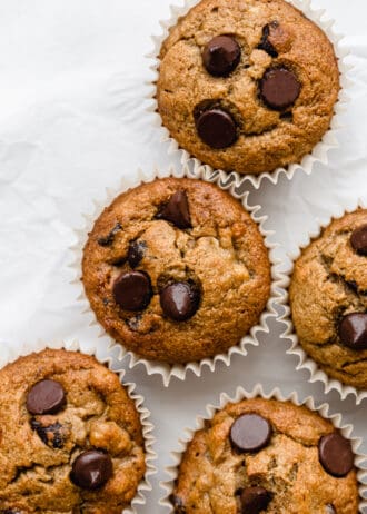 banana oat flour muffins with chocolate chips on parchment paper