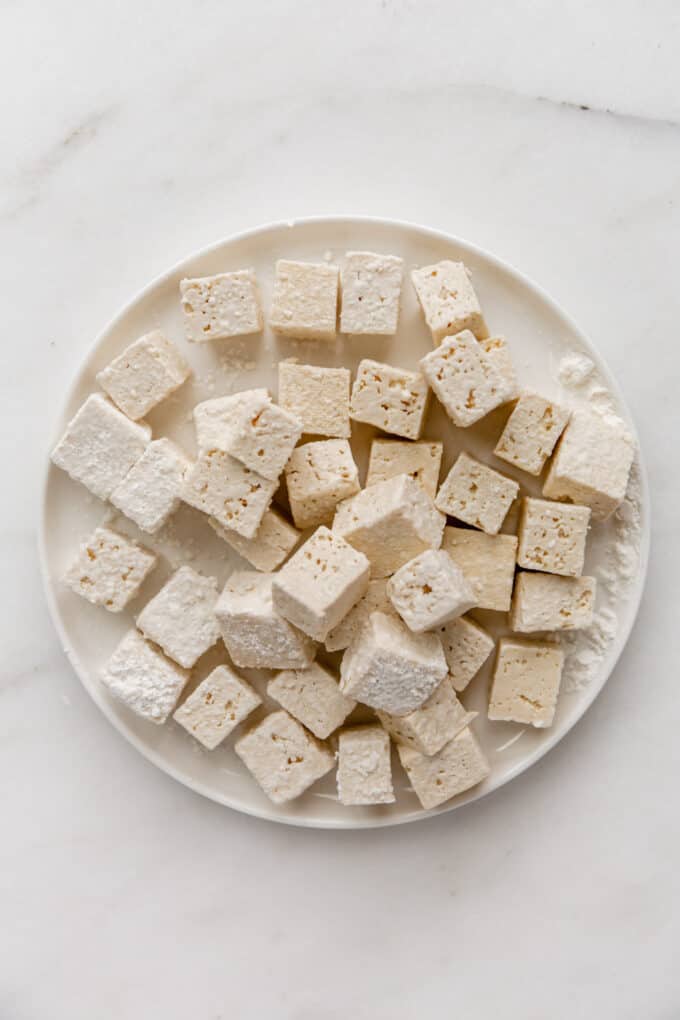 tofu cubes coated in cornstarch on a plate