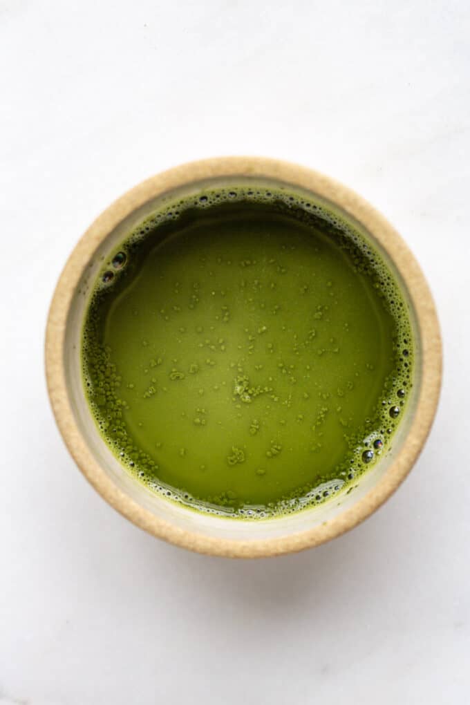 matcha powder mixed with water in a small bowl