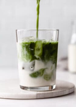 matcha being poured into a glass of oat milk