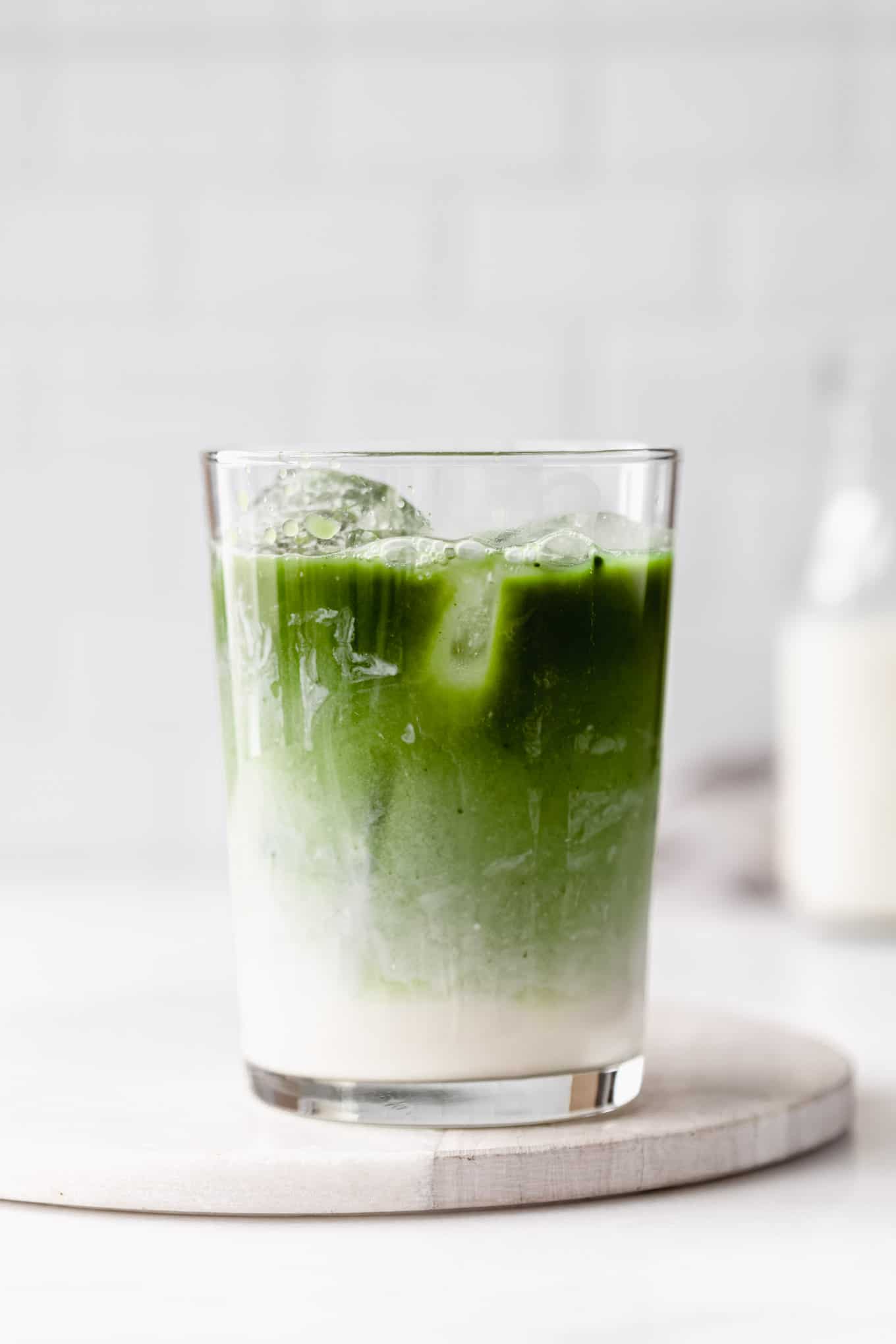 a glass of iced matcha latte on a marble board
