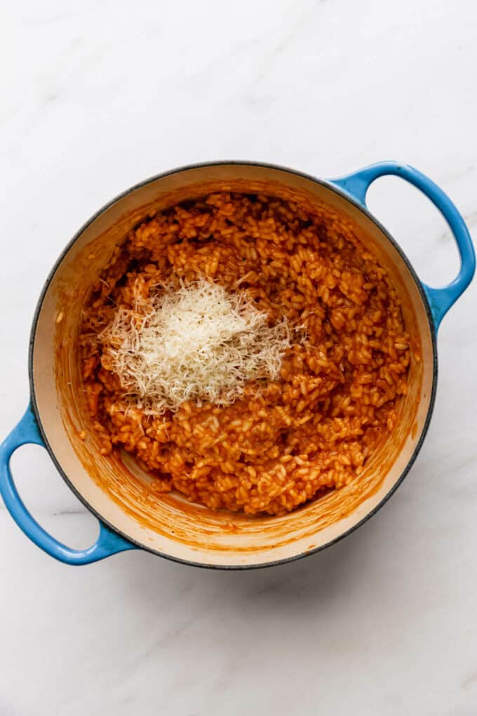 tomato risotto, parmesan cheese and basil in a blue pot