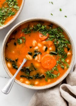 white bean and kale soup topped with chopped parsley