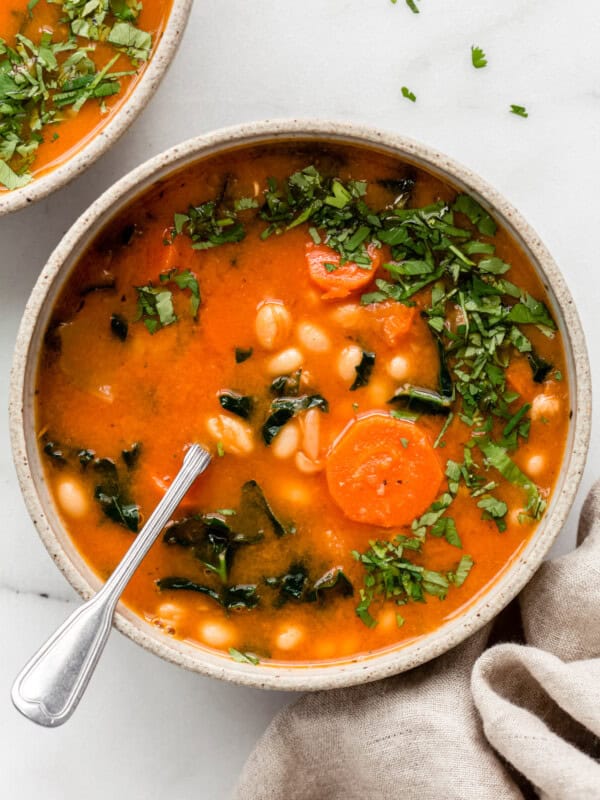 white bean and kale soup topped with chopped parsley