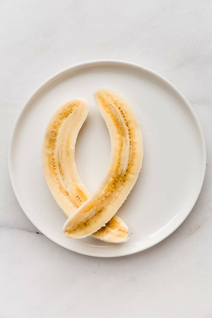 a sliced banana on a white plate