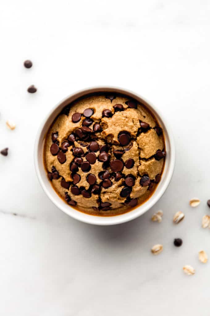 a ramekin of cookie baked oat with some chocolate chips on the side