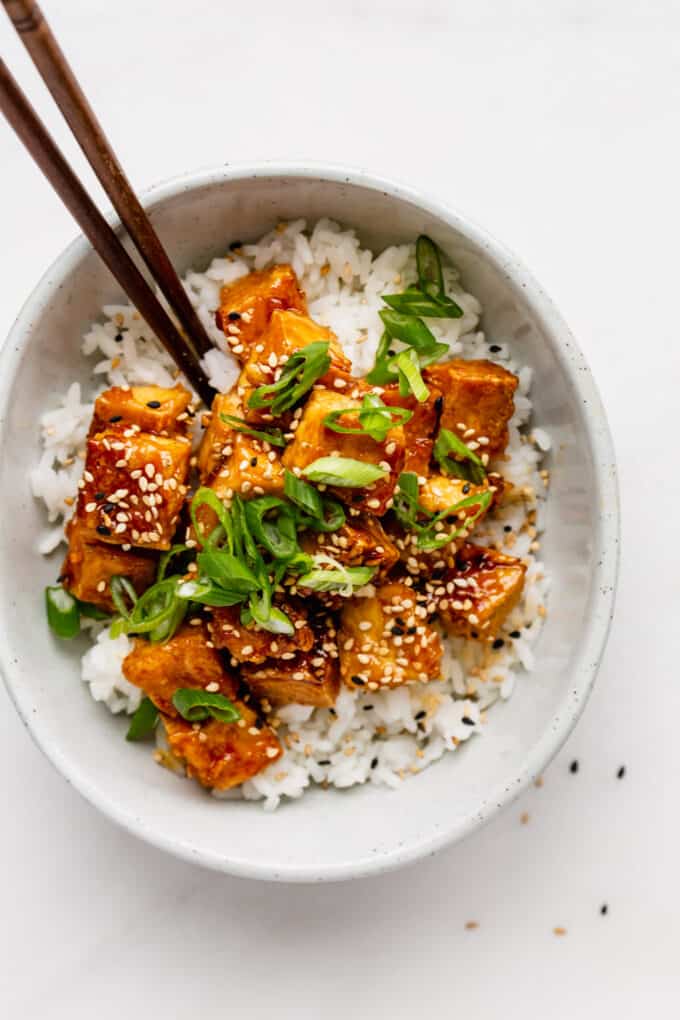 rice and honey garlic tofu in a bowl with chopsticks