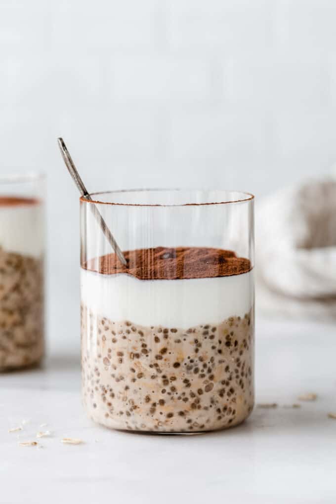 a cup of tiramisu overnight oats layered with yogurt and cocoa powder