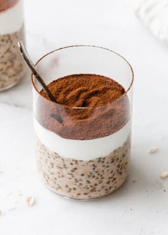 Tiramisu overnight oats in a cup topped with cocoa powder