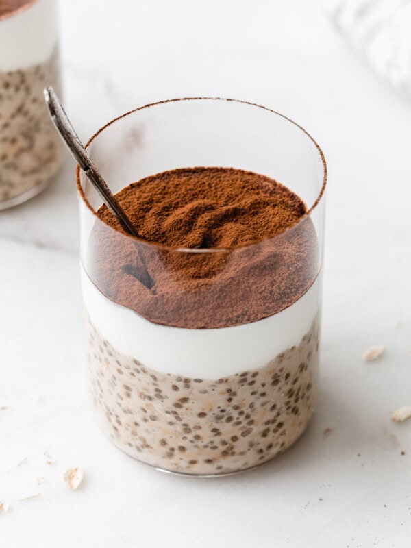 Tiramisu overnight oats in a cup topped with cocoa powder