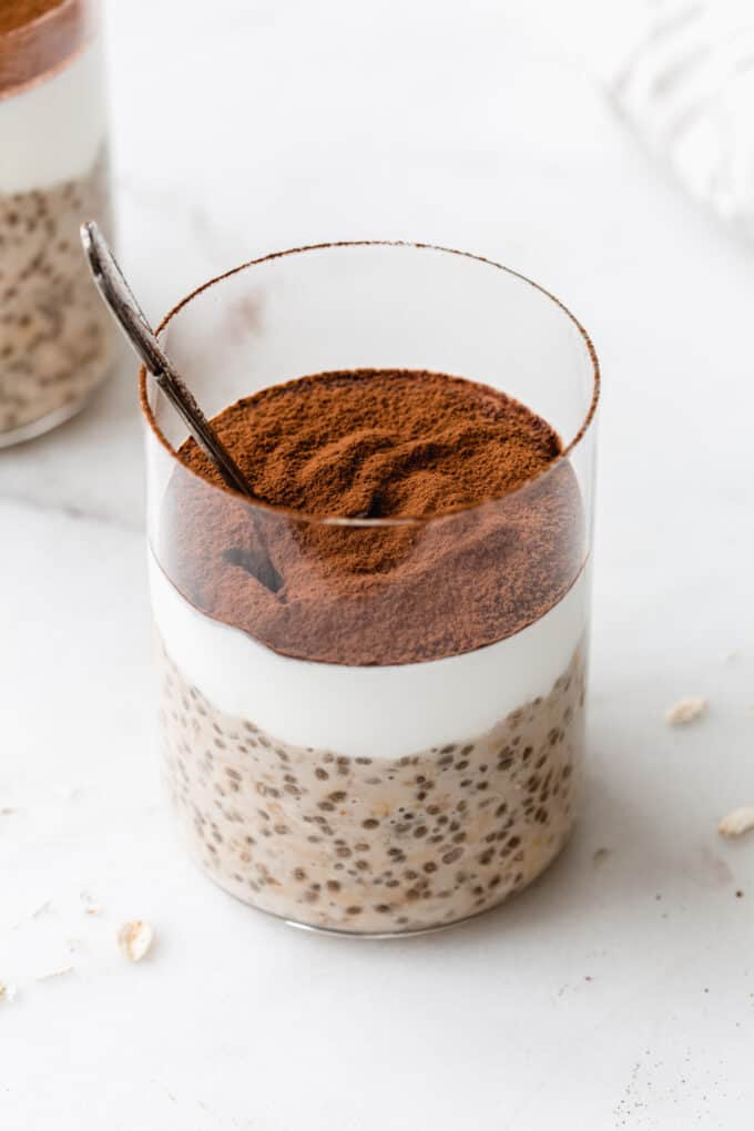 Tiramisu overnight oats in a cup topped with cocoa powder