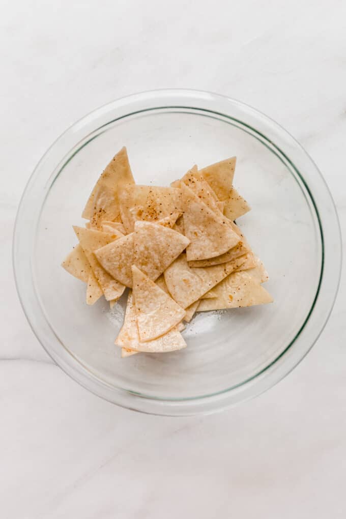 sliced tortilla chips in a clear mixing bowl