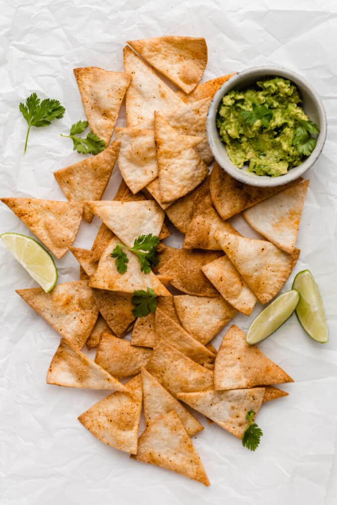 air fryer tortilla chips with a bowl of guacamole on the side