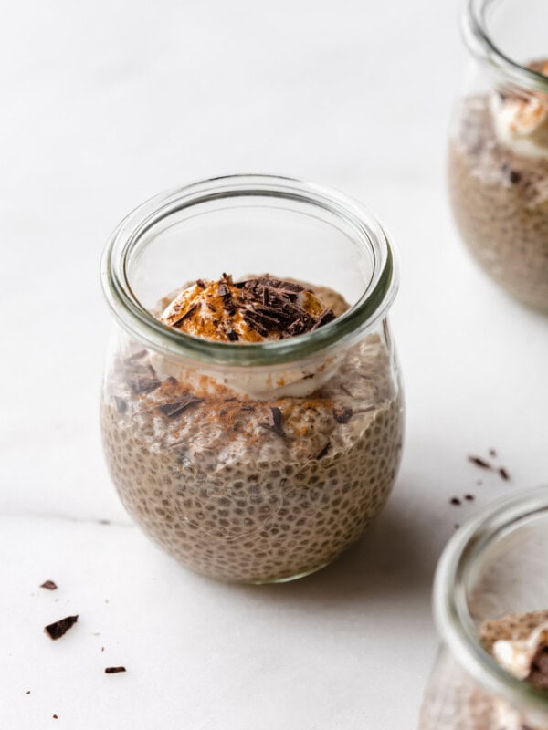 a jar of coffee chia pudding topped with yogurt, cinnamon and chocolate