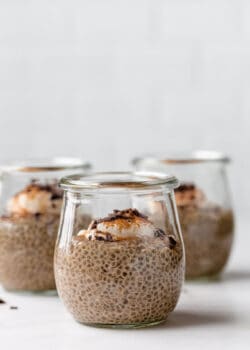 coffee chia pudding in 3 small jars topped with yogurt and cinnamon