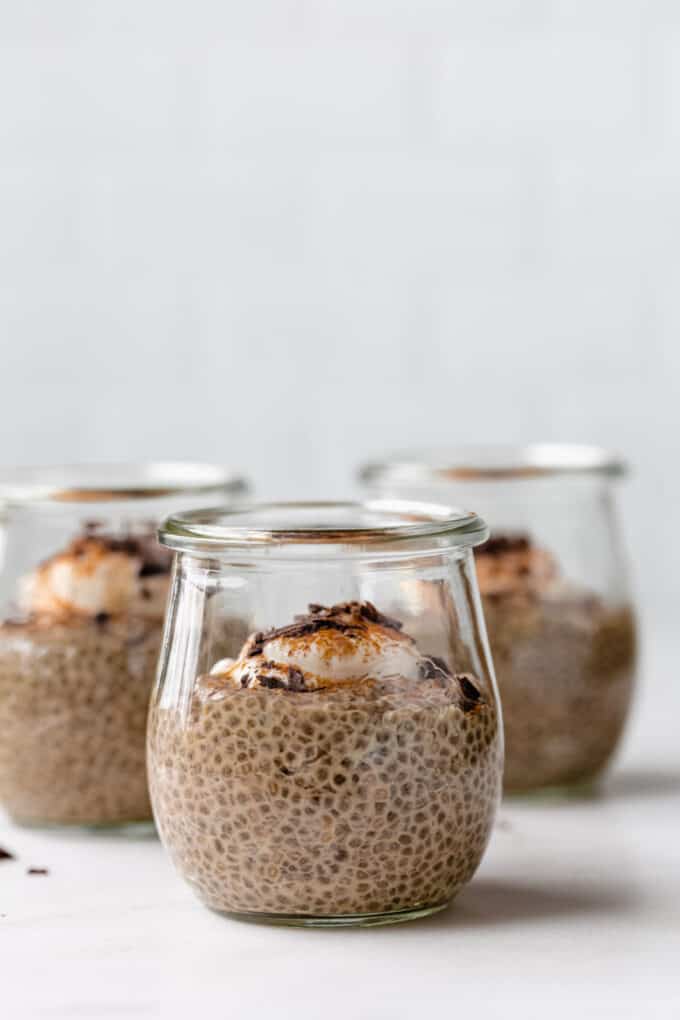 coffee chia pudding in 3 small jars topped with yogurt and cinnamon