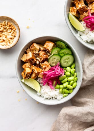 tofu, cucumber, edamame and pickled onions in a bowl with rice