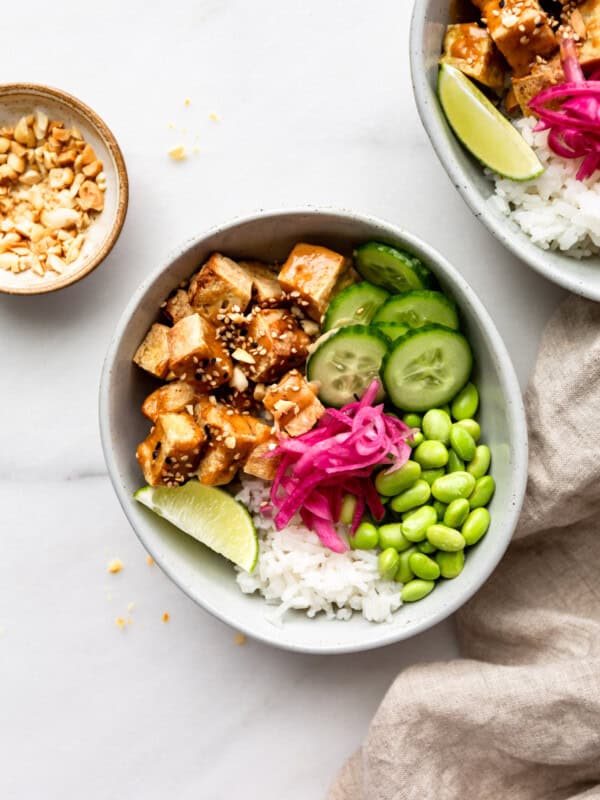 tofu, cucumber, edamame and pickled onions in a bowl with rice