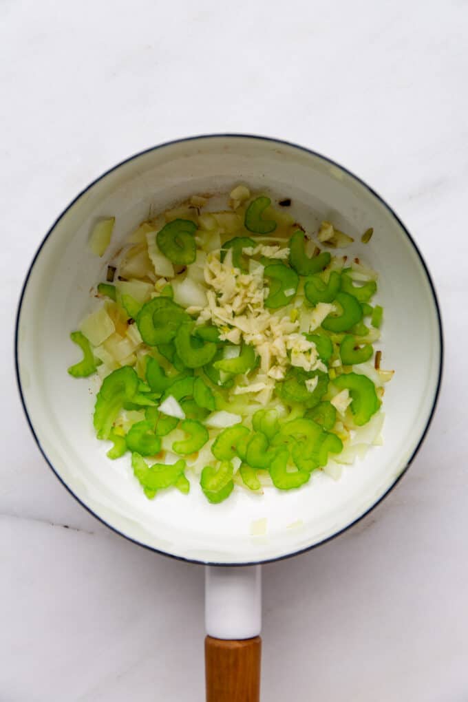 celery, garlic and onion in a white pot