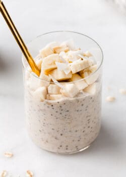 banana overnight oats in a cup with a gold spoon