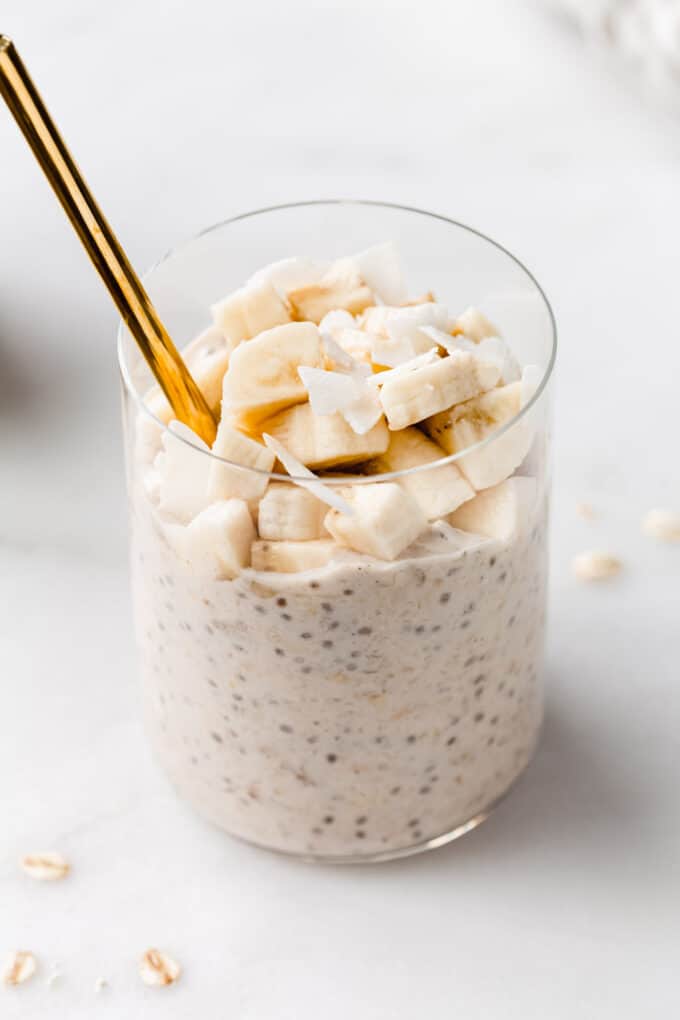 banana overnight oats in a cup with a gold spoon