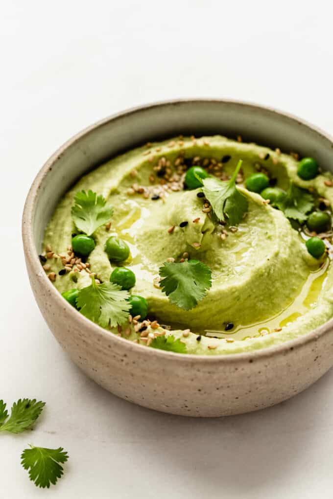 Green pea hummus in a ceramic bowl